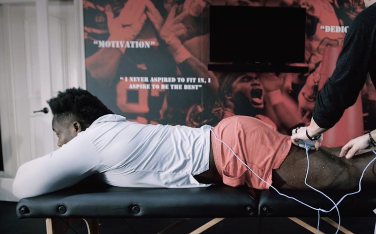 Grady Jarrett lying face down on a treatment table while a coach places pads on the back of his leg