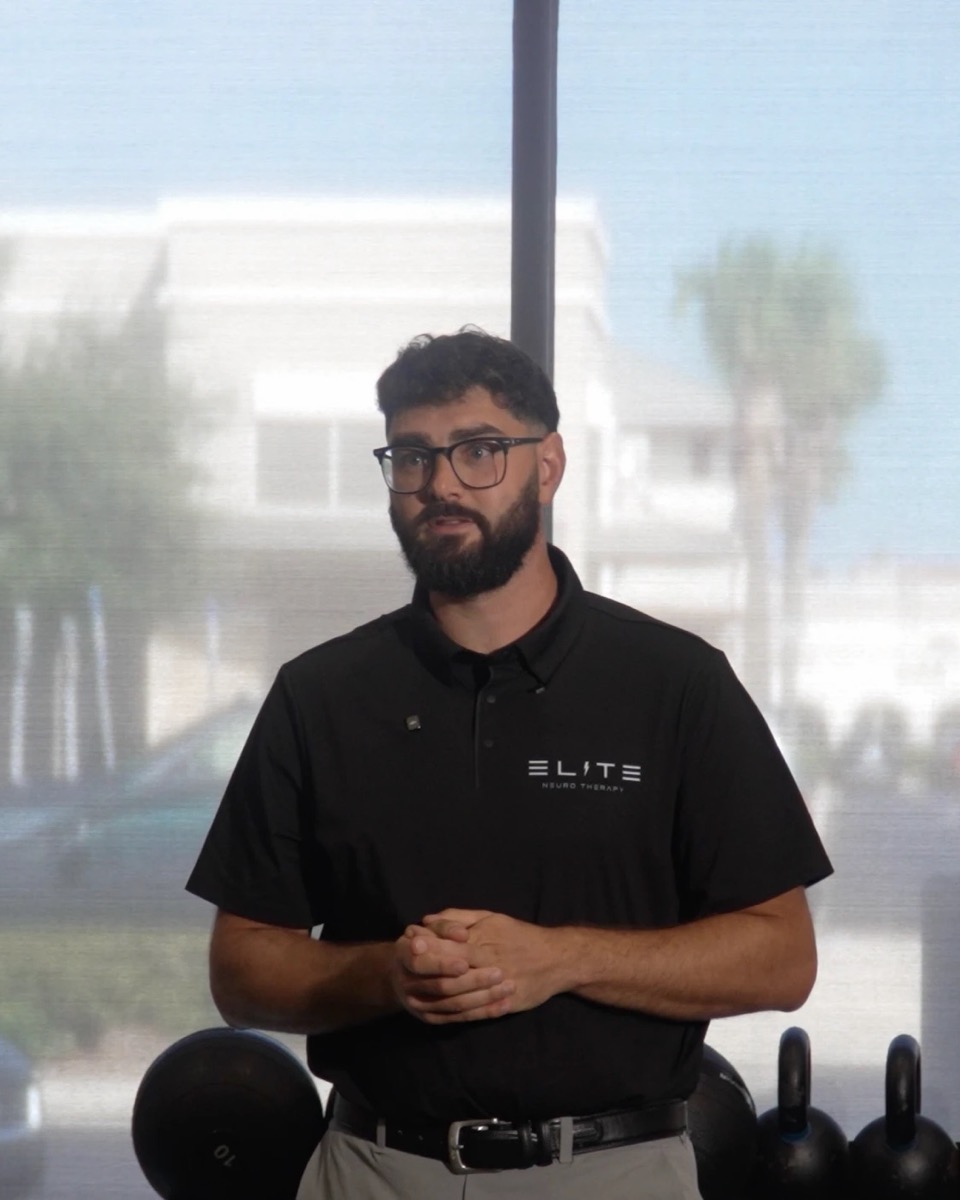 Dr. Jarod Burton speaking in an Elite Neuro Therapy polo